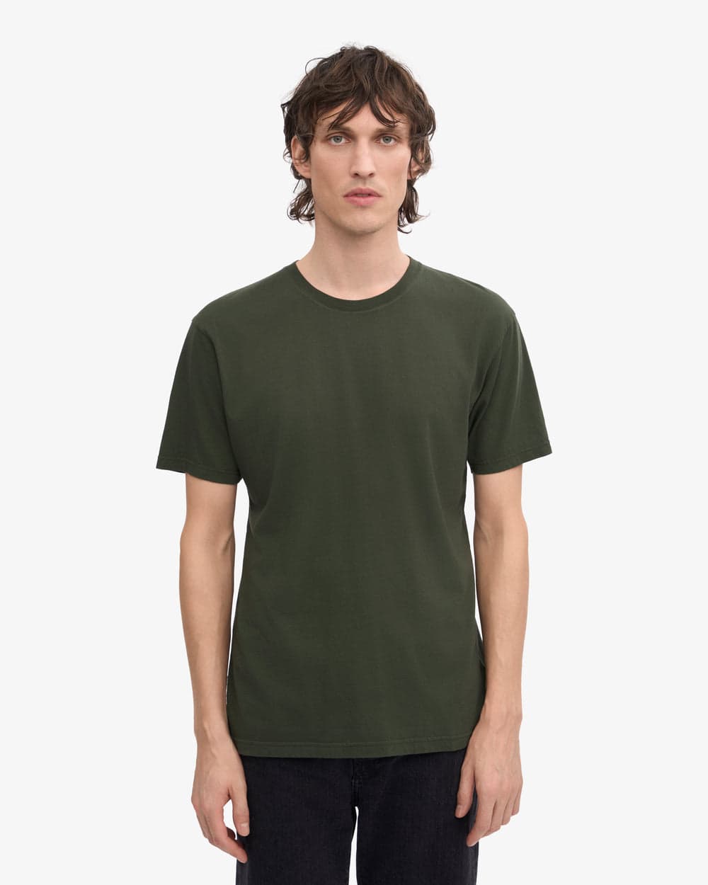 Model wearing a green Colorful Standard T-shirt